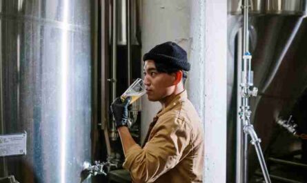 Asian man sampling craft beer in a modern brewery setting., tags: die - pexel